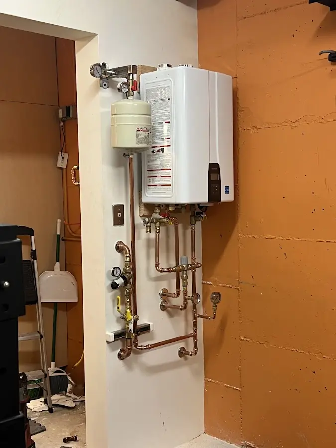 Plumbing technician inspecting water heater connections in Desert Hills